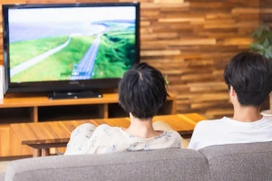 テレビを見る男女の写真