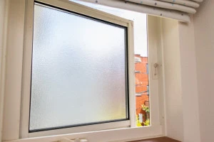 少し開いたすりガラスの小窓の写真