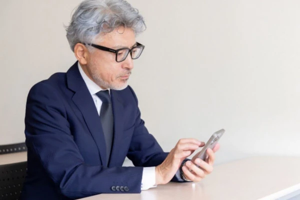 スマートフォンで検索をしている中年男性