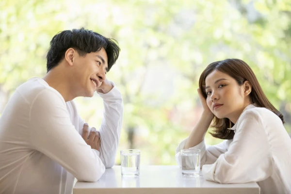 退屈そうな女性とデート中の男性の写真