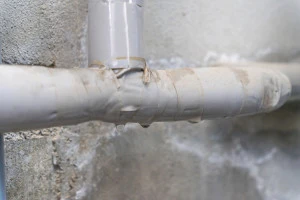 老朽化した水道管からの水漏れの写真