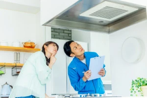 換気扇をチェックする作業員の写真