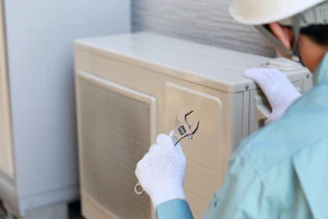 エアコンの室外機を修理する業者の写真