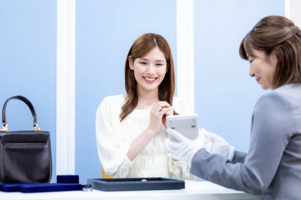 買取業者に査定をしてもらっている女性の写真