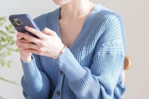 スマホを持つ女性の写真