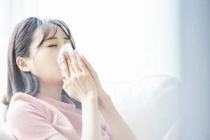 鼻をかむ女性の写真