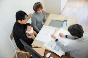 建築士にリフォームの相談をするファミリーの写真