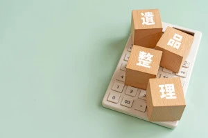 遺品整理と書かれたブロックと電卓の写真