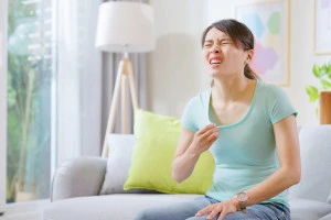 部屋の中で暑がる女性の写真