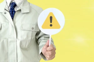 注意マークを持った作業員の写真