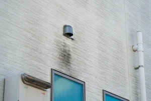 汚れた壁にある排気口の写真