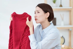 セーターの臭いを嗅ぐ女性の写真