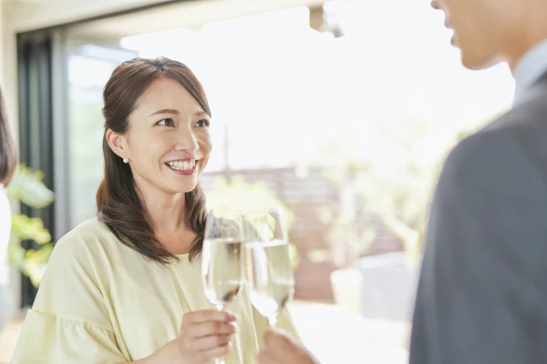 笑顔で乾杯をする男女の写真