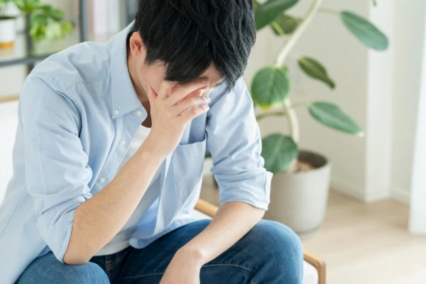 悩む若い男性の写真