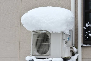 室外機の上に雪が積もっている写真