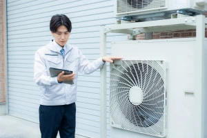 エアコンの室外機を点検をする作業員の写真①