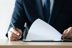 書類をめくるビジネスマンの手元写真