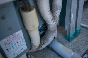 汚れたエコキュートの配管の写真
