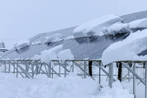 雪の塊が積もった太陽光パネルの写真