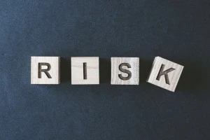 リスクと書かれた木製のブロックと黒背景の画像