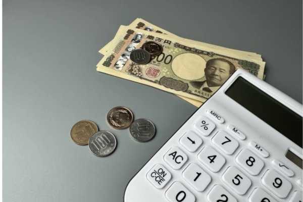 電卓とお金が机に広げられている様子