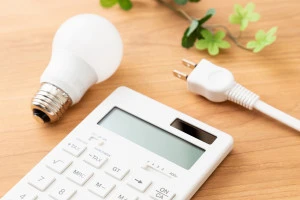 机に置かれた電卓とコンセントプラグの写真