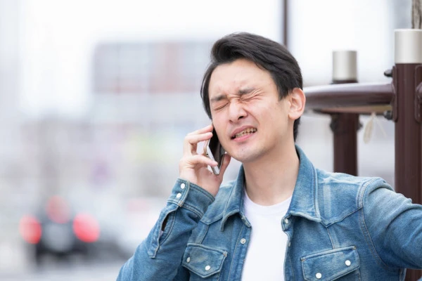 困った顔をしてスマホで電話をかけている男性