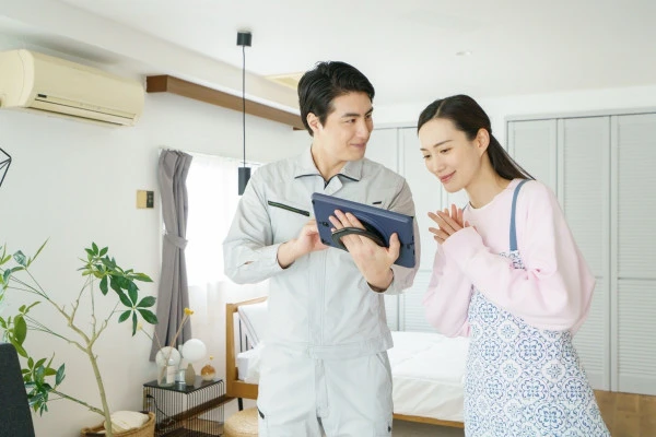 住宅で住人と相談する作業員の写真