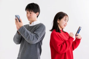 スマホを見る男女の写真