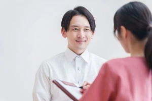 病院を受診する男性患者の写真