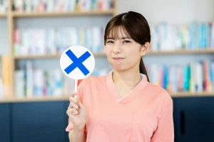 NGのプレートを出す女性の写真