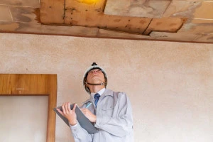 雨漏りした天井を調査する専門事業者の写真