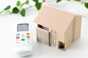 エアコンのリモコンと家の画像