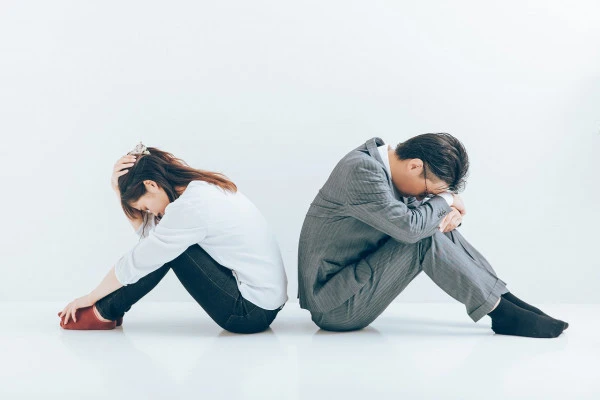 頭を抱える男女の写真