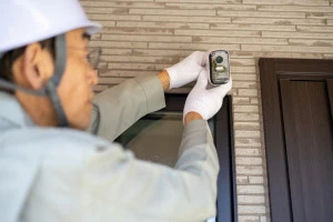 戸建て住宅の外壁に防犯カメラを取り付けようとしているところ