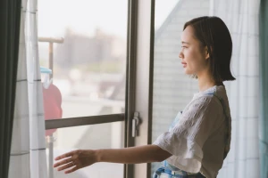 網戸のすき間を閉じている女性の写真