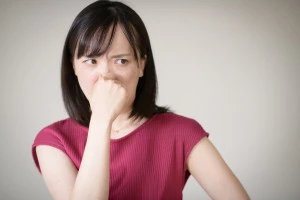 鼻をつまむ女性の写真