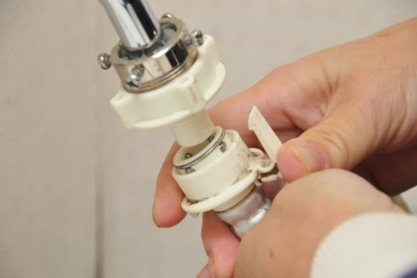 洗濯機の給水ホースから水漏れしたため部品を外す様子