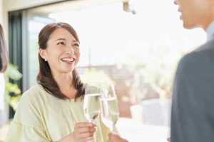 笑顔で乾杯をする男女の写真