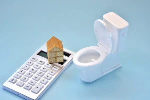 トイレと家の模型と電卓の画像