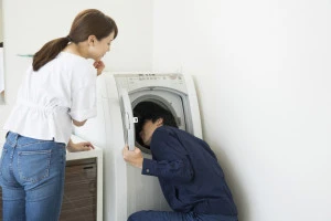 洗濯機の点検を行う業者の写真
