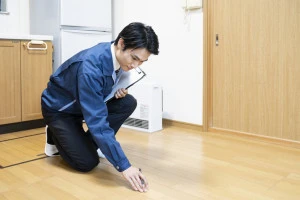 フローリングの点検をする作業員の写真