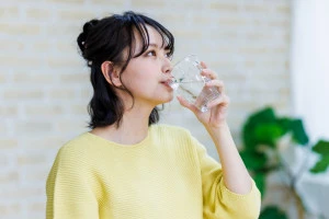 水を飲む若い女性の写真