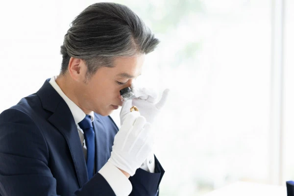 貴金属の査定を行う男性の写真