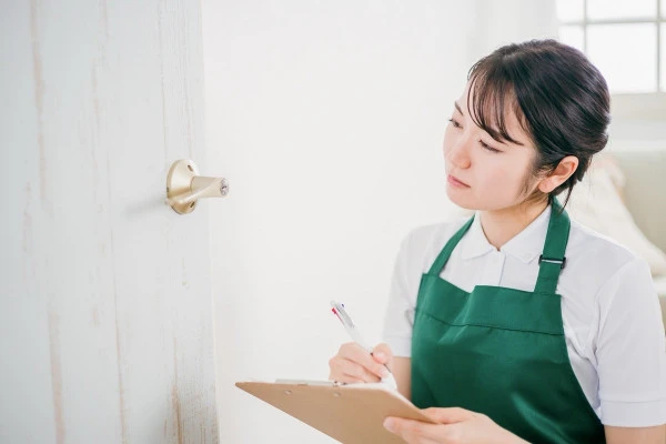 ドアノブの状態を確認する女性の写真