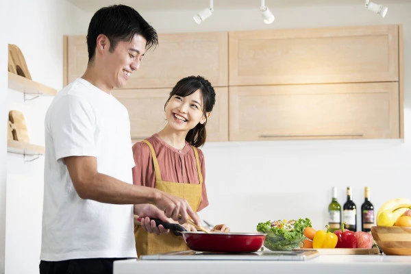 一緒に料理をする夫婦の写真