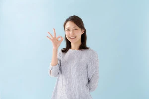 サインを出す女性の写真