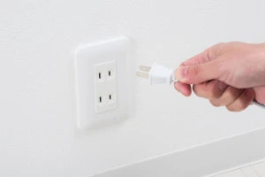 洗濯機のプラグを抜いている写真