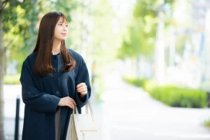 屋外を歩くコートの女性の写真