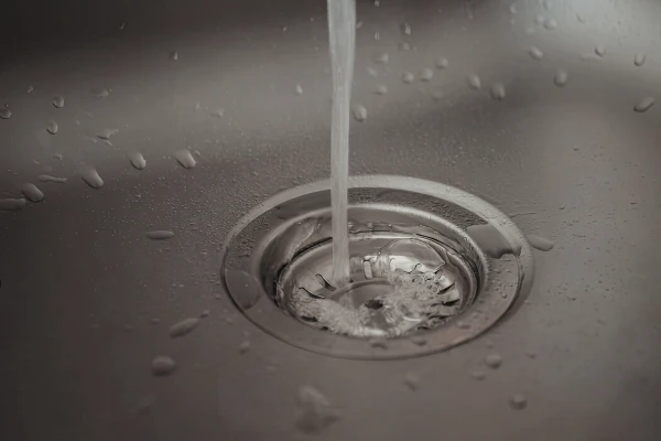 キッチンの排水口に水が流れている様子